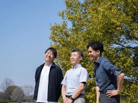 3人が木の下で笑っている様子を横から撮った写真